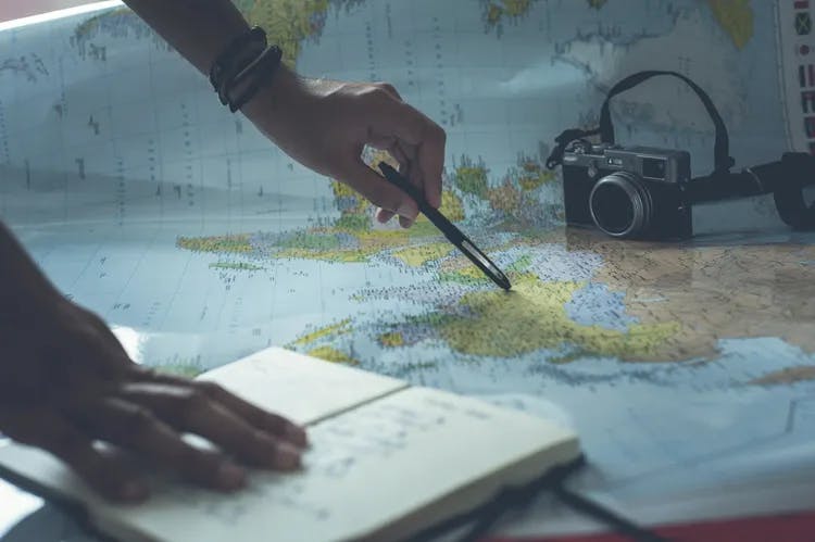 A person planning while a world map is laid on the table